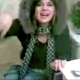A girl wearing a hooded winter jacket is seen sitting on a toilet. She says that she is only peeing, but the guy filming her complains about the smell. Is she lying to us?
